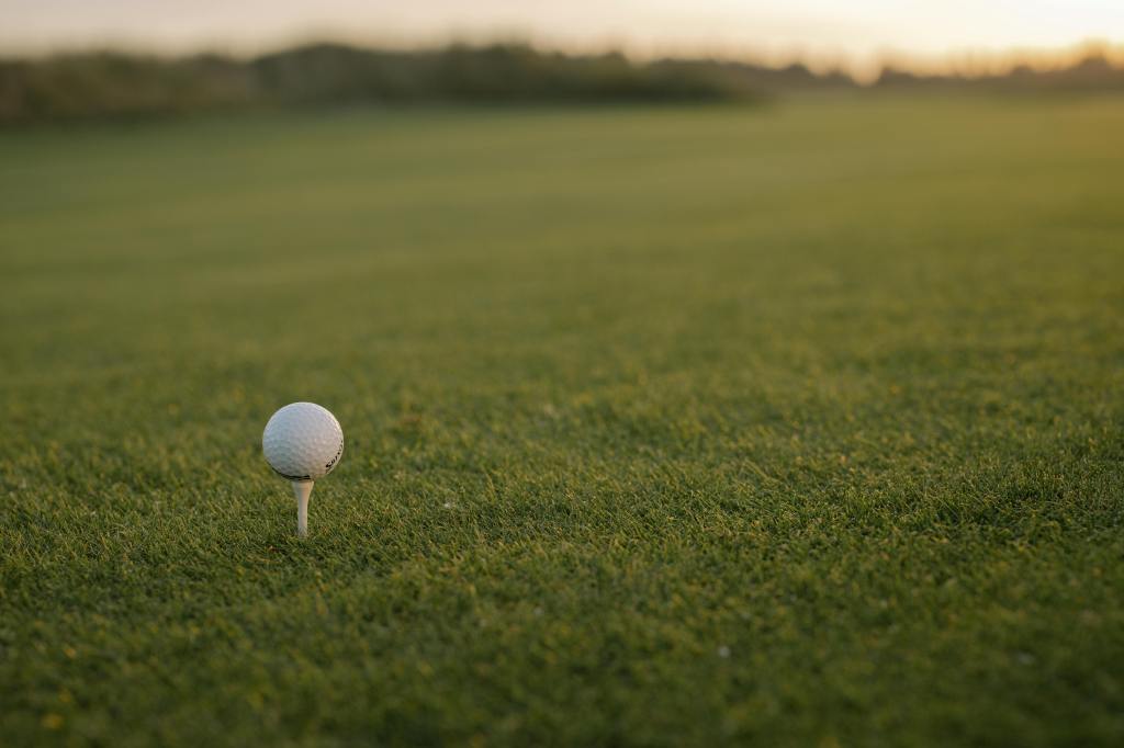 Golf ball on tee at sunrise